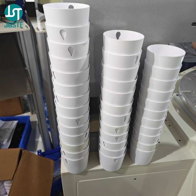 Cylindrical plastic parts awaiting screen printing on JST-R300-ACSM feeding conveyor