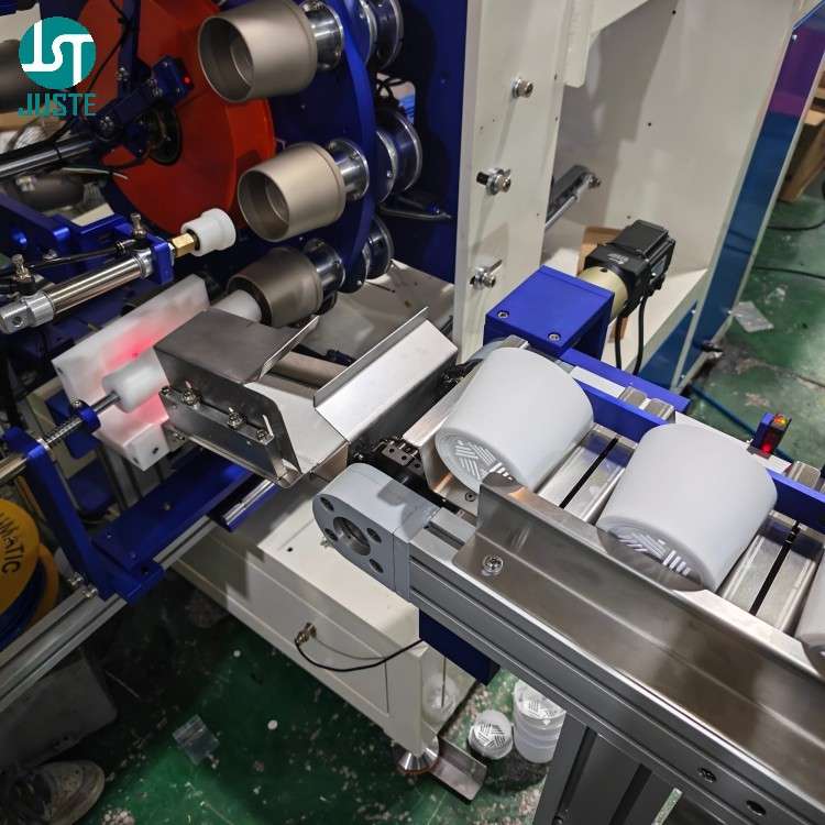 Operator loading cylindrical plastic parts onto feeding conveyor for screen printing machine